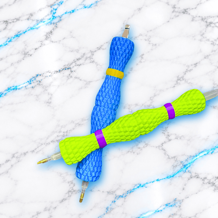 Deux crayons ergonomiques Drako'Stylé pour Diamond Painting croisés, bleu avec bagues jaunes et vert fluo avec bagues violettes, texture en écailles de dragon.