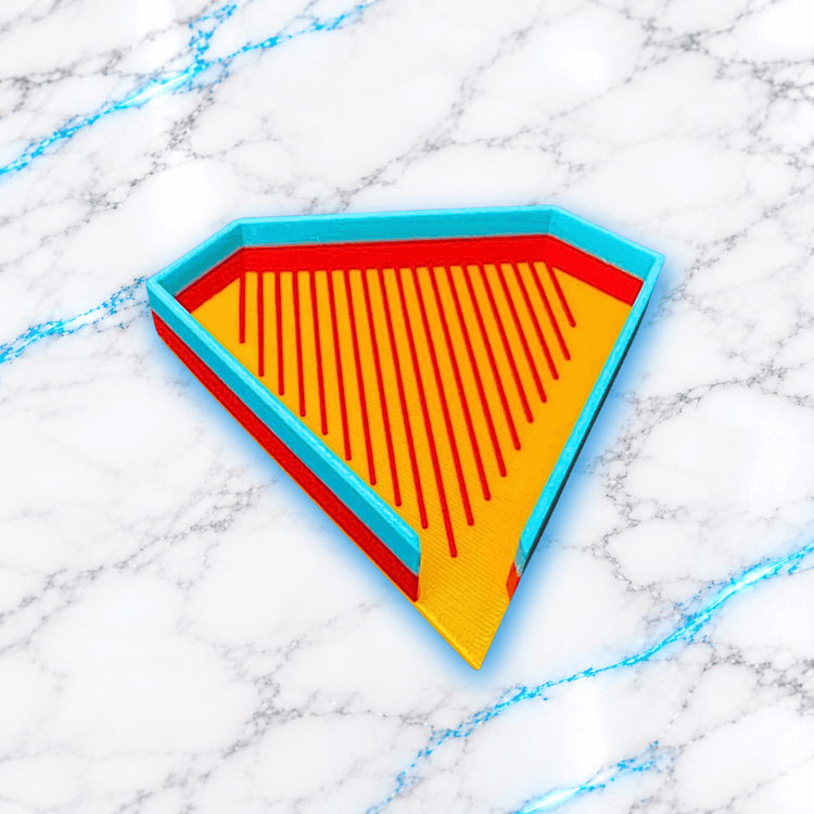 Plateau 3D Diamond Painting Le Diamantable UnBrunBarbu, vue en perspective, de forme triangulaire avec fond jaune orangé, rainures rouges pour aligner les diamants et bordures turquoise, sur fond marbré blanc aux veines bleues.