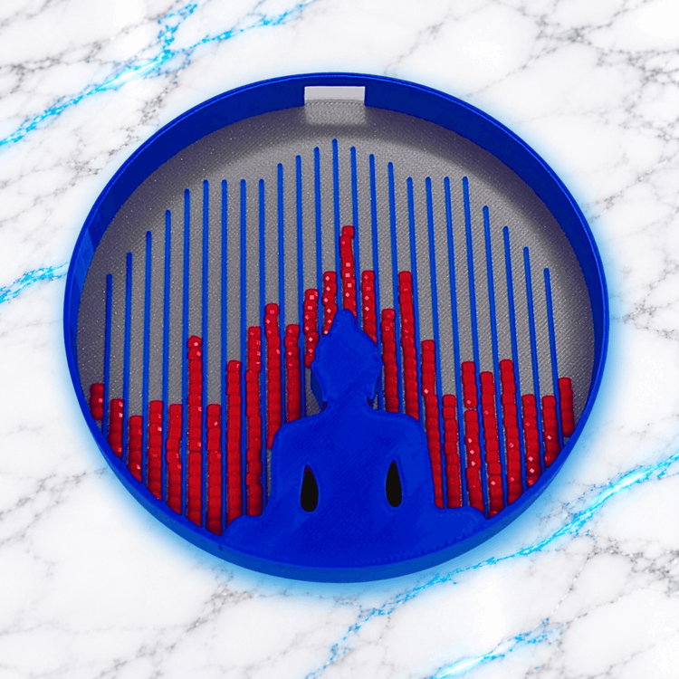 Plateau 3D Diamond Painting Le Plateau Zen UnBrunBarbu, de forme ronde, avec contour bleu, fond gris, silhouette de Bouddha en méditation et diamants carrés rouges alignés dans les rainures bleues, sur fond marbre blanc veiné de bleu.