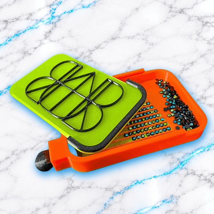 Plateau 3D Diamond Painting Le No Washi Wavy UnBrunBarbu orange avec couvercle vert anis à motifs géométriques noirs, présenté entrouvert avec des diamants ronds multicolores dans les rainures et le compartiment de récupération, sur fond marbré blanc aux veines bleues.