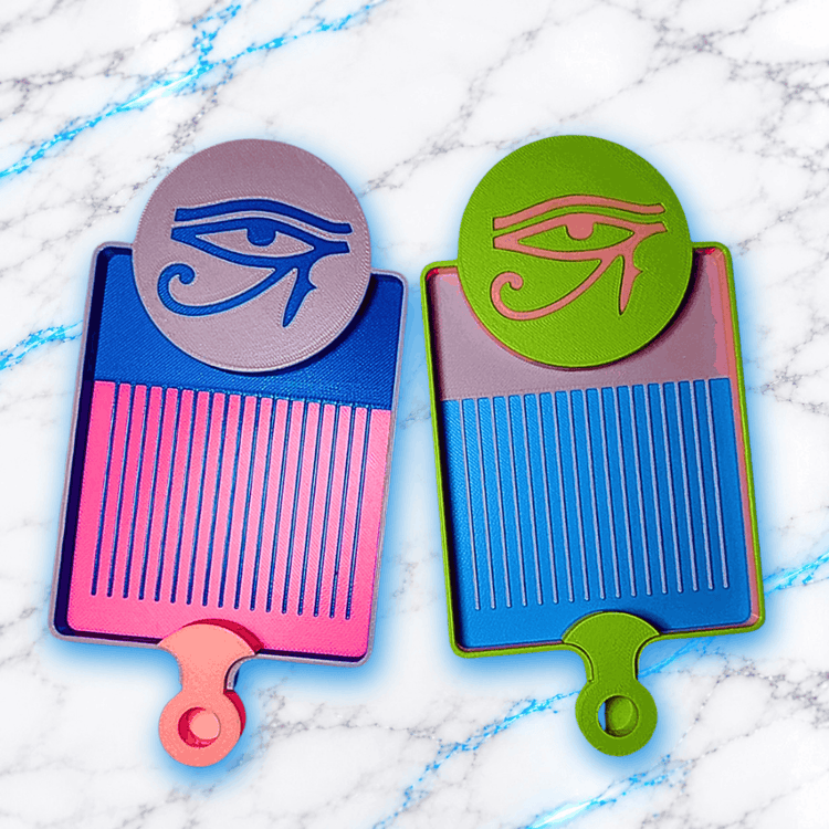Deux plateaux 3D Diamond Painting Symbole Égyptien UnBrunBarbu, ornés de l’œil d’Horus en relief, l’un rose et bleu avec médaillon mauve, l’autre bleu et vert avec médaillon vert et symbole rose, sur fond marbré blanc et bleu.