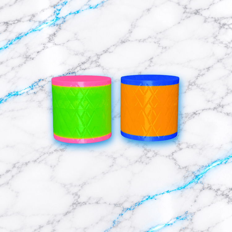 Deux mini poubelles Diamond Painting cylindriques imprimées en 3D, avec motifs géométriques en relief, l'une verte et rose, l'autre orange et bleue, sur fond marbre blanc veiné de bleu – UnBrunBarbu.