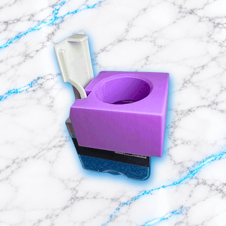 Adaptateur boîte pour Diamond Painting UnBrunBarbu imprimé en 3D, accessoire violet avec ouverture circulaire et système de fixation, présenté sur une boîte transparente bleue, sur fond marbre blanc veiné de bleu électrique.