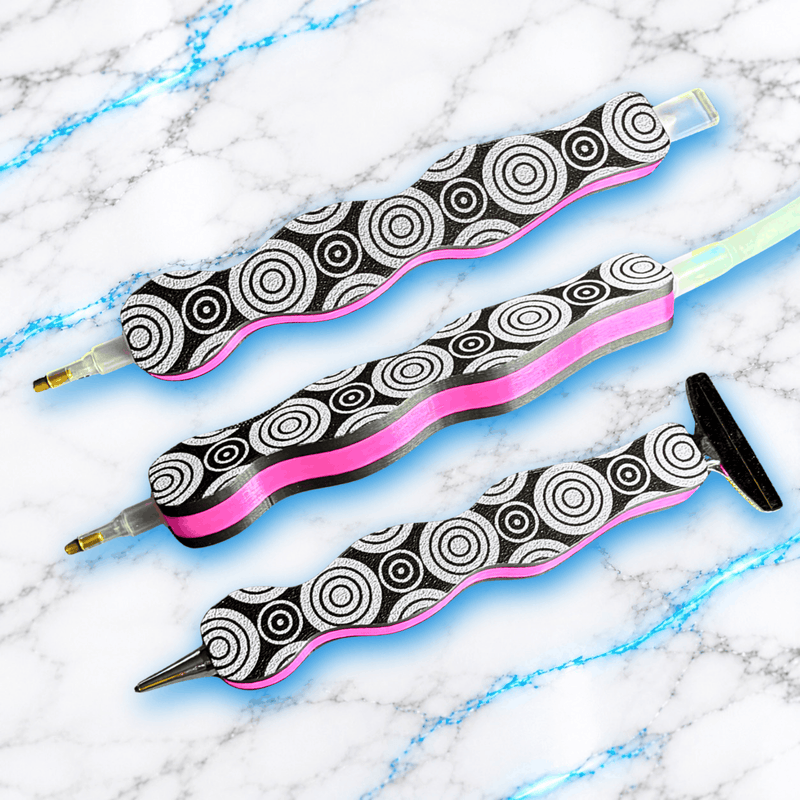 Crayon 3D ergonomique pour Diamond Painting UnBrunBarbu, personnalisé avec une gravure de cercles concentriques, finition noire et argentée avec bande rose, présenté sous trois angles avec différents embouts.