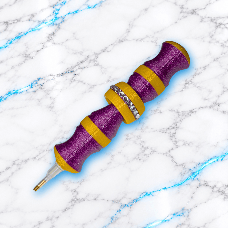 Crayon 3D GlitterPen pour Diamond Painting violet pailleté et doré, avec manche ergonomique, bague anti-stress centrale ornée de strass et pointe métallique pour broderie diamant.