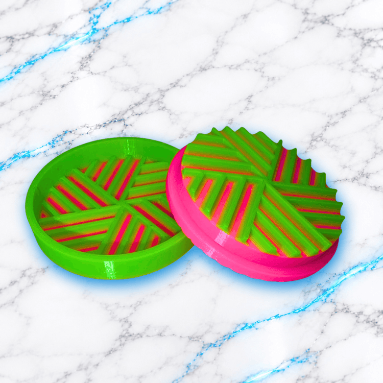 Grinder boîte séparateur à diamants pour Diamond Painting UnBrunBarbu, accessoire imprimé en 3D vert fluo et rose fuchsia, présenté ouvert avec ses deux parties rondes et ses rainures pour séparer les diamants.