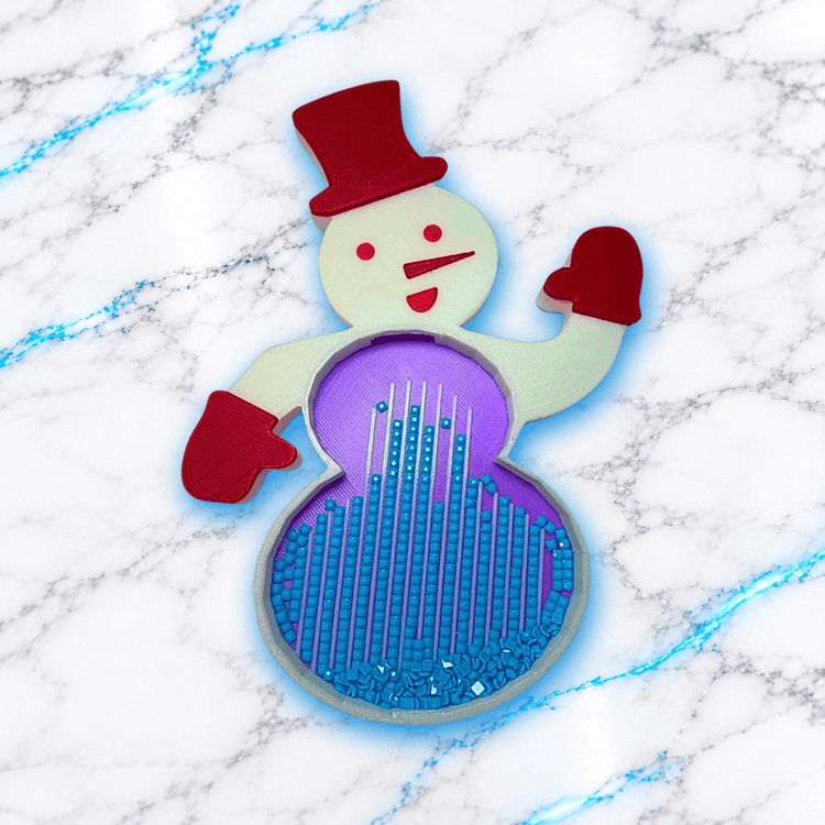 Plateau 3D Diamond Painting en forme de bonhomme de neige avec chapeau et moufles rouges, intérieur violet et diamants carrés bleus alignés dans les rainures, création UnBrunBarbu.