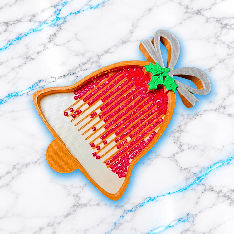 Plateau 3D Diamond Painting Cloche de Noël orange et doré, décoré d'un nœud argenté et de feuilles de houx vertes, avec des diamants carrés rouges alignés dans les rainures, création UnBrunBarbu.