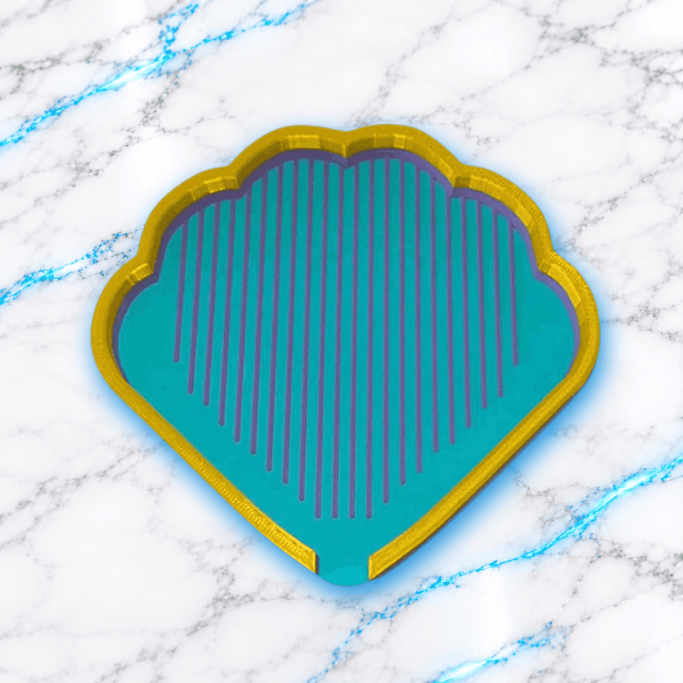 Plateau 3D Diamond Painting Le Coquillage UnBrunBarbu, vue de dessus, en forme de coquillage avec bordure dorée, fond turquoise et rainures violettes pour aligner les diamants, sur fond marbré blanc aux veines bleues.