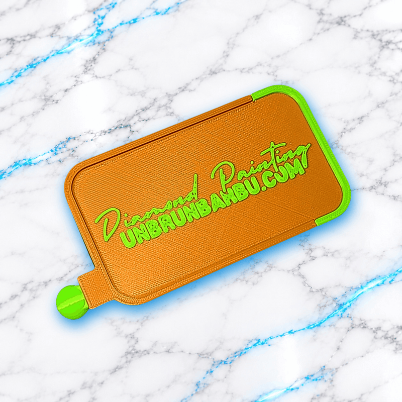 Plateau 3D Diamond Painting No Washi Wavy Medium orange métallisé et vert fluorescent en position fermée, avec couvercle coulissant et inscription UnBrunBarbu en relief vert.