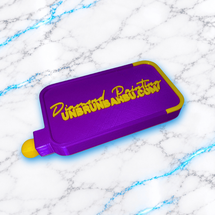 Plateau 3D Diamond Painting No Washi Wavy Medium violet et jaune en position fermée, avec couvercle coulissant et inscription Diamond Painting UnBrunBarbu en relief.