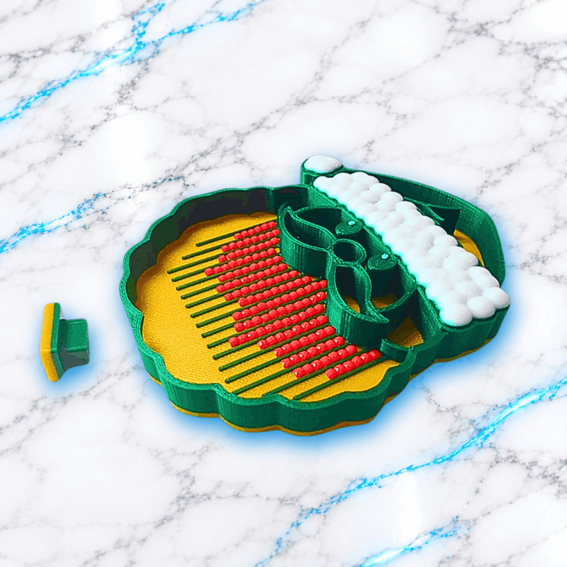 Plateau 3D Diamond Painting Père Noël UnBrunBarbu vu en perspective, avec bordures vertes, fond doré, rainures pour aligner les diamants carrés rouges et bonnet blanc en relief, sur fond marbré blanc et bleu.