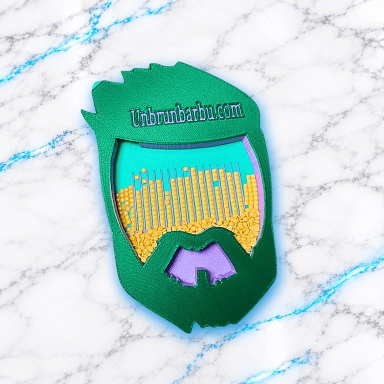 Vue de dessus du plateau 3D Diamond Painting UnBrunBarbu en forme de visage barbu vert, avec inscription Unbrunbarbu.com, fond turquoise, rainures de tri remplies de diamants carrés jaunes et détails violets, sur fond marbré blanc et bleu.